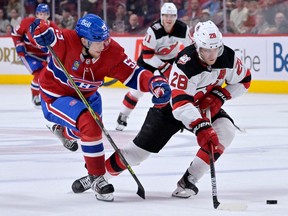 New Jersey Devils defenceman Damon Severson plays the puck as Montreal Canadiens forward Jan Mysak defends during the third period at the Bell Centre in Montreal on Sept. 26, 2022.