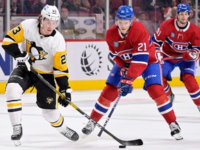Pittsburgh Penguins forward Brock McGinn plays the puck as Montreal Canadiens' Kaiden Guhle defends during the first period at the Bell Centre in Montreal on Oct. 17, 2022.