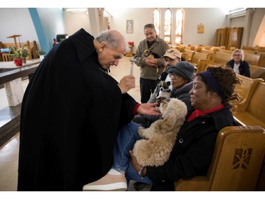 Sainte-Catherine-de-Sienne parish priest Jean-Pierre Couturier blesses Ranee Lee's dog Cali ("Montreal's Queen of Jazz" calls Cali her constant companion) at a Blessing of the Animals event at the church in Notre-Dame-de-Grâce on Sunday, Oct. 2, 2022.