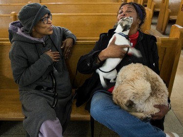 Michele Henegan's dog Beanie licks Ranee Lee (Michele's mother), holding her dog Cali, at a Blessing of the Animals event at the Sainte-Catherine-de-Sienne Church in  Notre-Dame-de-Grâce on Sunday, Oct. 2, 2022.