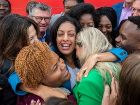 Quebec Liberal Party leader Dominique Anglade, centre, is hugged by local candidates following a news conference while on an election campaign stop in Montreal, Saturday, Oct. 1, 2022.