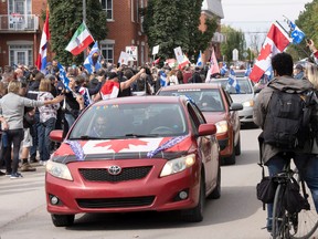 People take part in a protest against the Coalition Avenir Québec government of François Legault in his home riding Saturday, Oct. 1, 2022 in L'Assomption.