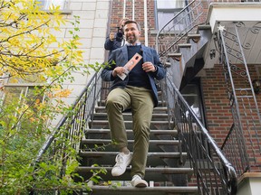 Québec solidaire co-spokesperson Gabriel Nadeau-Dubois walks down a staircase after placing an election flyer of candidate Guillaume Cliche-Rivard on the door of a home as he tours the riding of Saint-Henri—Sainte-Anne during an election campaign stop in Montreal, Saturday, Oct. 1, 2022.