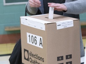 A voter casts their ballot in the Quebec provincial election, on Oct. 3, 2022, in Montreal. A Superior Court judge has rejected a request by the Conservative Party of Quebec to have a recount in a Quebec City-area riding it lost by a slim margin to the Coalition Avenir Québec on Oct. 3.