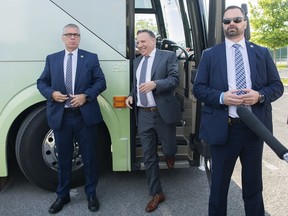 Flanked by security, Coalition Avenir Québec Leader François Legault arrives for a news conference during an election campaign stop in Montreal, Saturday, Sept. 3, 2022. Quebec provincial police say 31 people were arrested for threats against candidates during the province's recently completed election campaign.