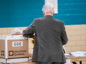 A man prepares to vote during the Quebec election Oct. 3, 2022.
