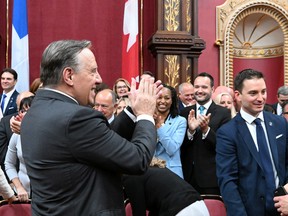 Quebec Premier François Legault applauds his caucus after they were sworn in, Tuesday, Oct. 18, 2022 during a ceremony at the legislature in Quebec City.