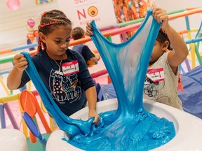 Twins Olivia and Savannah Hernandez play with slime at the Sloomoo Institute in New York.