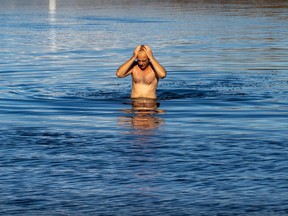 A man cools off in the water off Verdun beach on a second-summer day Oct. 25, 2022.