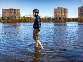 Husein Abdallah strolls in the water on a warm second summer day at the beach in Verdun Oct. 25, 2022.