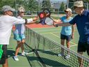 Roland Chammas (far right) congratulates Naren Thakrar (far left), Lisa Marie Mills (no hat) and Susan Sowerby following a pickleball game at the Ecclestone Park tennis courts in Kirkland on Monday July 5, 2021.
