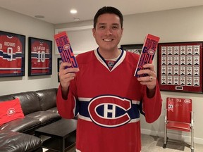 Canadiens fan Rob Hing in his Calgary home holding the season-ticket package he received after spending 10 years on the team's waiting list.