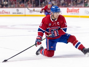 Montreal Canadiens centre Nick Suzuki looks to make a play from one knee during third period against the Arizona Coyotes in Montreal on Oct. 20, 2022.