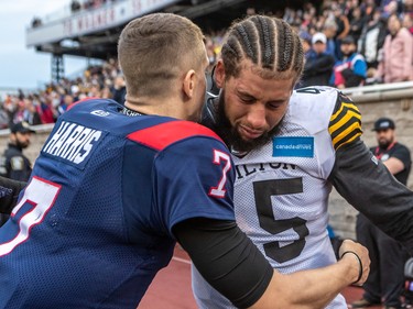 Alouettes quarterback Trevor Harris (7) consoles Hamilton Tiger Cats linebacker Jovan Santos-Knox after defeating the Tiger-Cats 28-17 to win the CFL Eastern Conference semifinal game at Molson Stadium in Montreal on Sunday, Nov. 6, 2022.