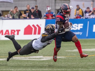 Hamilton Tiger-Cats linebacker Simoni Lawrence (21) attempts to bring down Alouettes running back Walter Fletcher (25) during first half CFL Eastern Conference semifinal action at Percival Molson Stadium in Montreal on Sunday, Nov. 6, 2022.