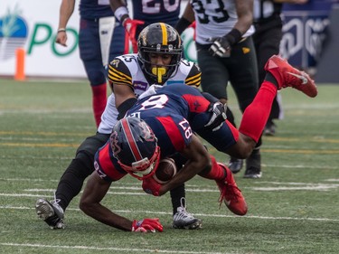 Alouettes wide receiver Eugene Lewis (87) is taken down by Hamilton Tiger-Cats defensive back Jumal Rolle (25) during first half CFL Eastern Conference semifinal action at Percival Molson Stadium in Montreal on Sunday, Nov. 6, 2022.