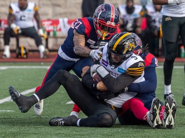 Alouettes defensive lineman Mike Moore (44) and teammate defensive back Wesley Sutton (37) sack Hamilton Tiger-Cats quarterback Dane Evans (9) during first half CFL Eastern Conference semifinal action at Percival Molson Stadium in Montreal on Sunday, Nov. 6, 2022.