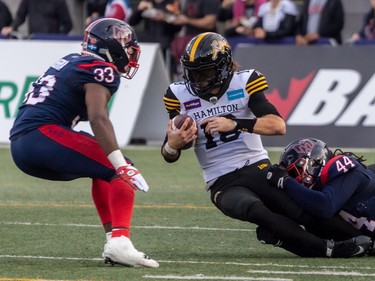Hamilton Tiger-Cats wide receiver Marcus Davis (18) is tackled by Alouettes defensive lineman Mike Moore (44) and teammate linebacker Keishawn Bierria (33) during second half CFL Eastern Conference semifinal action at Molson Stadium in Montreal on Sunday, Nov. 6, 2022.
