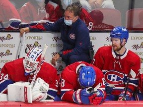 Montreal Canadiens equipment manager Pierre Gervais, goalie Jake Allen, from left, and defencemen Ben Chiarot, Brett Kulak and David Savard look on during the final minute of a loss to the Carolina Hurricanes in Montreal on Oct. 21, 2021.