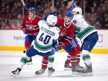 Canadiens centre Kirby Dach (77) hits Vancouver Canucks centre Elias Pettersson (40) sending him to the ice during NHL action in Montreal on Wednesday, Nov. 9, 2022.