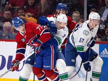 Vancouver Canucks defenceman Luke Schenn (2) struggles to get past Montreal Canadiens centre Kirby Dach (77) during NHL action in Montreal on Wednesday, Nov. 9, 2022. Vancouver Canucks defenceman Tyler Myers (57) is seen at right.