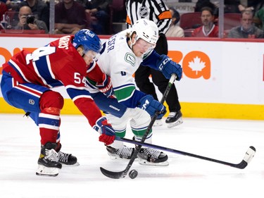 Canadiens defenceman Jordan Harris (54) tries to disarm Vancouver Canucks right wing Brock Boeser (6) during NHL action in Montreal on Wednesday, Nov. 9, 2022.