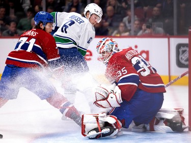 Canadiens goaltender Sam Montembeault (35) stops Vancouver Canucks right wing Brock Boeser (6) as Montreal Canadiens centre Jake Evans (71) looks on during NHL action in Montreal on Wednesday, Nov. 9, 2022.
