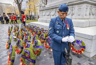 Corporal Richard Condor of the 438 Squadron of the Royal Canadian Air Force stands with his head bowed at the cenotaph during Remembrance Day ceremony in Montreal on Friday, Nov. 11, 2022.