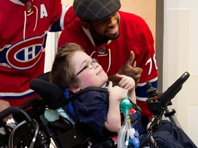 Loic Bydal, 11, gives a thumbs-up with Montreal Canadiens' P.K. Subban during a team visit at the Montreal Children's Hospital on Dec. 8, 2015.