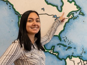 Isabelle Lessard smiles while pointing out Chapais on a map of North America