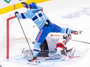 Montreal Canadiens winger Josh Anderson avoids contact with New Jersey Devils' Vitek Vanecek after being hooked from behind during third period in Montreal on Nov. 15, 2022.