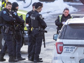 Police with rifles arrive outside Collége Lionel-Groulxi n Ste-Therese, north of Montreal, on Friday, Nov. 18, 2022, after reports of a suspicious individual outside the CEGEP.