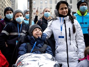 Sixteen-year-old Fernado smiles as he watches the Santa Claus parade in Montreal on Saturday, Nov. 19, 2022.