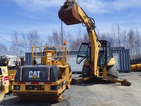 An image provided by the CNESST shows a backhoe and chain that was used to hold open a platform on a roller compactor. The unsafe procedure led to the platform becoming unhooked, causing fatal injuries to a mechanic on May 9, 2022 at Rouyn Asphalte Inc. in Rouyn-Noranda.