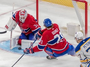 Montreal Canadiens defenceman Kaiden Guhle (21) watches as Montreal Canadiens goaltender Jake Allen (34) covers up the loose puck during 3rd period NHL action against the Buffalo Sabres at the Bell Centre in Montreal on Tuesday Nov. 22, 2022.