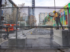 Workers secure a section of the three-metre-high security fence around the Palais des congrès in Montreal Thursday Nov. 24, 2022 ahead of the COP15 conference happening in December.