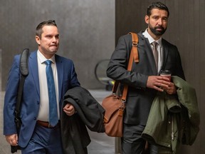 Two Montreal police officers — Pierre-Luc Furlotte, left, and Patrick Guay — arrive for their trial at the Montreal courthouse on Monday Nov. 28, 2022. They are alleged to have apprehended Tobie Charles Angers Levasseur somewhere in Montreal on March 31, 2010, and to have driven him off the island to a remote location where he was left to fend for himself.