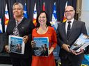 Montreal Mayor Valérie Plante, flanked by executive committee chair Dominique Ollivier and director general Serge Lamontagne show off  the city's 2023 budget binders on Tuesday, Nov. 29.