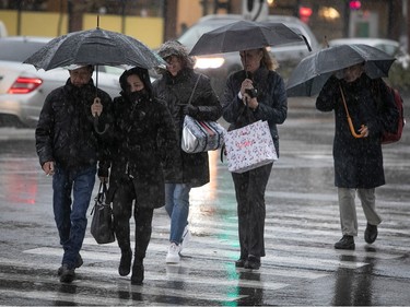 Pedestrians holding umbrellas walk along Jean-Talon St. in Montreal on Wednesday Nov. 30, 2022.