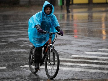 Negotiating the rain, a cyclist crosses Jean-Talon St. in Montreal on Wednesday Nov. 30, 2022.