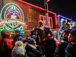 Alex Croxen, right with his daughter, Zahira, "came out to see the beautiful lights" as the CP Holiday train pulled into the Beaconsfield train station on Sunday, Nov. 27, 2022.