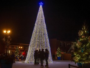 Skaters are silhouetted by the lit Christmas tree at the outdoor skating rink in Pointe-Claire Village last year.