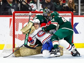 The Wild’s Jared Spurgeon checks the Canadiens’ Brendan Gallagher in front of goalie Marc-André Fleury during third period of Tuesday night’s game at the Xcel Energy Centre in Minnesota. The Wild won the game 4-1.