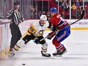 Marcus Pettersson (28) do Pittsburgh Penguins e Sean Monahan do Canadiens patinam após o disco durante o segundo período do jogo no Bell Centre no sábado, 12 de novembro de 2022 em Montreal.