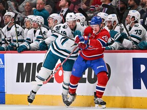 Canadiens' Christian Dvorak and Sharks' Tomas Hertl battle along the boards during third-period action Tuesday night at the Bell Centre.