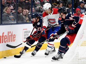 Jake Christiansen #23 and Erik Gudbranson #44 of the Columbus Blue Jackets compete for the puck with Johnathan Kovacevic #26 of the Montreal Canadiens during the third period at Nationwide Arena on Nov. 17, 2022 in Columbus, Ohio.