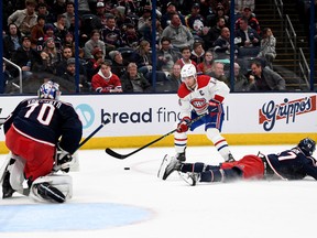 Nick Suzuki #14 of the Montreal Canadiens shoots and scores a goal against Marcus Bjork #47 and Joonas Korpisalo #70 of the Columbus Blue Jackets during the third period at Nationwide Arena on Nov. 17, 2022 in Columbus, Ohio.