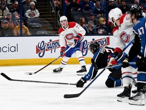 Kirby Dach of the Montreal Canadiens passes to David Savard to assist on a goal during the third period against the Blue Jackets at Nationwide Arena in Columbus, Ohio, on Nov. 23, 2022.