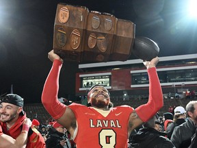 Laval Rouge et Or’s Kevin Mital celebrates with the Dunsmore Cup after defeating the Montreal Carabins in RSEQ Dunsmore Cup university football action in Quebec City on Saturday, Nov. 12, 2022.