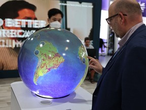 A delegate views an interactive Earth globe exhibit during the COP27 climate conference in Egypt's Red Sea resort city of Sharm el-Sheikh on November 14, 2022. "After 27 years of talk, how did we allow the warnings to become the crisis that exists today?" Keroles B. Riad asks.